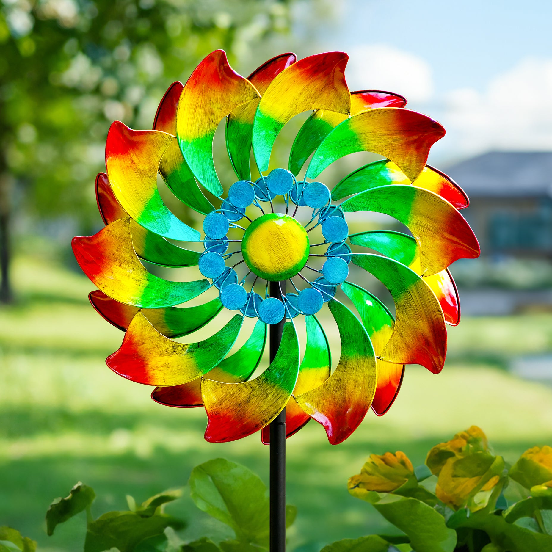 A colorful windmill made of red, yellow, green and blue gradient combinations, like a beautiful flower in the garden.