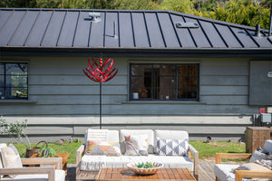 The red Cyan Oasis Lotus wind spinner forms a beautiful picture with the courtyard as the sunlight pours on the window sill in the peaceful afternoon.