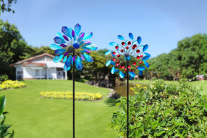 This image shows two colorful windmills, quietly standing in a lush green garden. A whitewashed house and elaborate courtyard are set against a backdrop of tranquility and beauty. The blue and red hues of the windmills complement the surrounding natural scenery, adding a sense of movement and contrast to the overall image.